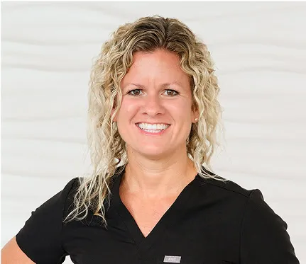 Kristen Personne, Executive Director, smiling in dental uniform